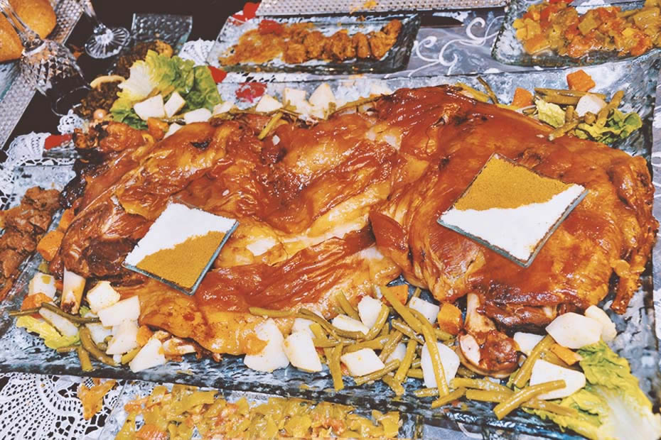 Moroccan mechoui surrounded by some vegetables.