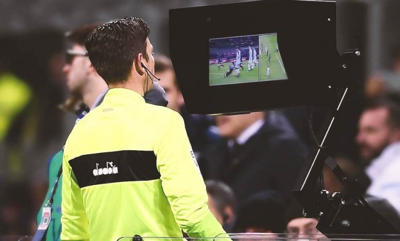 An arbitrator using a Video Assitant Referee (VAR) during a match