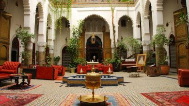 A majestic riad with some red furnitures, traditional Moroccan ithems and some decorative plants