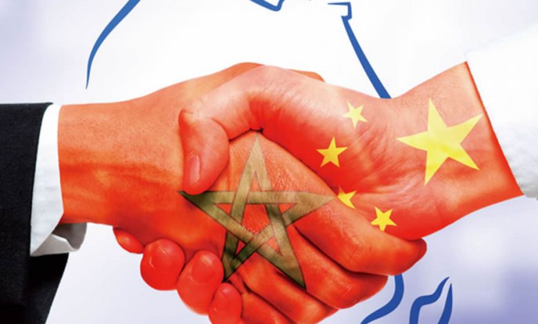 Handshake of two hands, on one is the Moroccan flag and on the other is the Chinese flag.