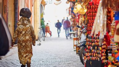 A Moroccan woman in a beautiful stylized djellaba walking in a Moroccan souk