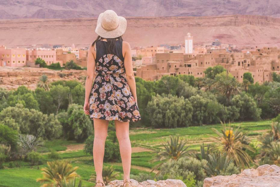 A woman wearing a short dress and a hat looking at the view of Morocco