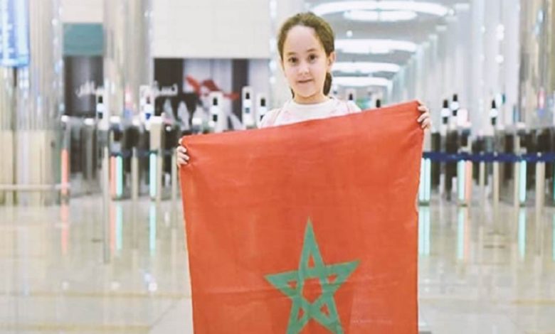 9-year-old Moroccan girl, Meriem Amjoune, winner of the Arab Reading Challenge 2018, holding the Moroccan flag.