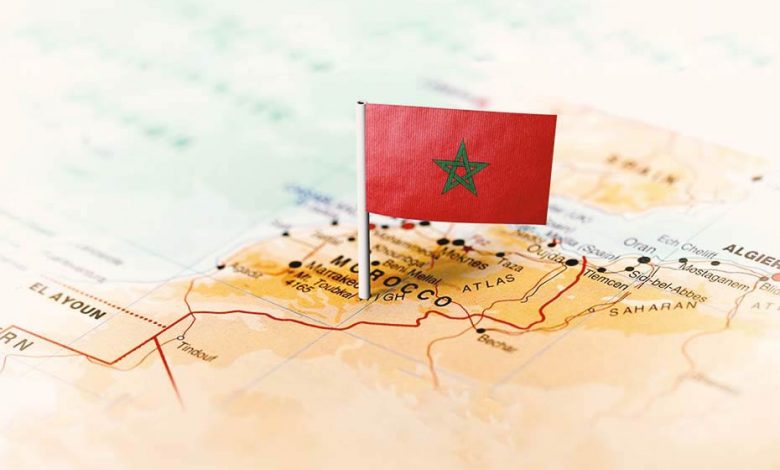 Moroccan flag pointing at Morocco on a world map