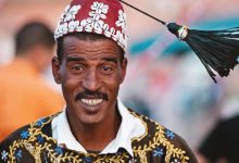A happy Moroccan man wearing traditional Moroccan Gnawa clothes
