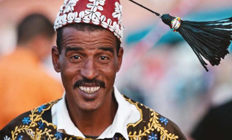 A happy Moroccan man wearing traditional Moroccan Gnawa clothes